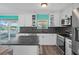Bright kitchen includes stainless appliances, hardwood flooring, and views of the waterway through the sliding door at 3362 Minnow Creek Dr, Hernando Beach, FL 34607