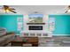 Modern living room featuring a sleek fireplace, mounted TV, and bright turquoise walls at 3362 Minnow Creek Dr, Hernando Beach, FL 34607