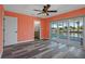 Bright main bedroom featuring wood floors, orange walls, a ceiling fan, and sliding doors to the outside area at 3362 Minnow Creek Dr, Hernando Beach, FL 34607