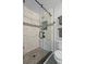 Close up of a modern shower with glass door, stone floors, and white marble-patterned tile walls at 3362 Minnow Creek Dr, Hernando Beach, FL 34607