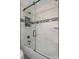 Close up of a modern shower with glass door, stone floors, and white marble-patterned tile walls with a built-in shelf at 3362 Minnow Creek Dr, Hernando Beach, FL 34607