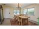 Cozy dining room featuring a wood table, chandelier, large windows, and a view of the home's entrance at 37623 Florida Ave, Dade City, FL 33525