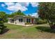 Charming single-story home featuring a well-maintained lawn, tidy landscaping, and a cheerful red front door at 37623 Florida Ave, Dade City, FL 33525
