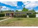 Inviting single-story home with a red front door, lush green bushes, and a neatly landscaped front yard at 37623 Florida Ave, Dade City, FL 33525