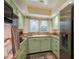 Compact kitchen featuring green cabinets, granite countertops, and stainless steel appliances at 37623 Florida Ave, Dade City, FL 33525