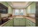 Efficient kitchen with green cabinetry, granite countertops, and modern appliances for cooking convenience at 37623 Florida Ave, Dade City, FL 33525