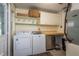 Well-lit laundry room featuring a washer, dryer, shelving, and cabinets for ample storage and organization at 37623 Florida Ave, Dade City, FL 33525
