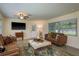 Bright living room featuring a comfortable seating area, a decorative rug, and natural light from the window at 37623 Florida Ave, Dade City, FL 33525