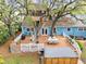 Aerial view of the backyard features a large deck, hot tub, treehouse, and mature trees at 417 Inness Dr, Tarpon Springs, FL 34689
