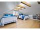 Bright bonus room with two beds, hardwood floors, sloped ceilings, and a storage unit at 417 Inness Dr, Tarpon Springs, FL 34689