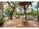 Spacious wooden deck with a treehouse, lounge seating, an outdoor dining table, and mature trees at 417 Inness Dr, Tarpon Springs, FL 34689