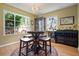 Bright dining area featuring hardwood floors, decorative chandelier and large windows overlooking the lush landscape at 417 Inness Dr, Tarpon Springs, FL 34689