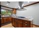 Bright kitchen with stainless vent hood, center island, hardwood floors, and cabinetry at 417 Inness Dr, Tarpon Springs, FL 34689