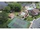 A beautiful aerial view of a community pool, tennis courts, shuffleboard, and clubhouse near a lake at 4647 Gazebo Ct, New Port Richey, FL 34655