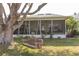 Charming backyard featuring a screened-in patio and a wooden swing hanging from a large, mature tree at 4647 Gazebo Ct, New Port Richey, FL 34655