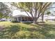Expansive backyard with lush green grass, a mature tree, and a screened-in patio, perfect for outdoor enjoyment at 4647 Gazebo Ct, New Port Richey, FL 34655