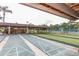View of shuffleboard courts featuring shaded seating and a view of tennis courts for enjoyable outdoor recreation at 4647 Gazebo Ct, New Port Richey, FL 34655
