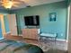 Primary bedroom features a dresser with a large TV, a bench seat and access to the ensuite bathroom at 4678 Marine Pkwy # 305, New Port Richey, FL 34652