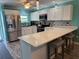 Bright kitchen with white cabinets, stainless steel appliances, mosaic tile backsplash, and quartz countertops at 4678 Marine Pkwy # 305, New Port Richey, FL 34652