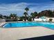 Community swimming pool surrounded by lounging chairs and tropical landscaping providing a relaxing atmosphere at 4678 Marine Pkwy # 305, New Port Richey, FL 34652