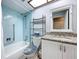 Bright bathroom features a blue tiled shower and a granite vanity with white cabinets at 4836 Alamo Ct, New Port Richey, FL 34655