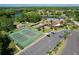 Aerial view of community tennis courts and pool overlooking beautiful lake at 4836 Alamo Ct, New Port Richey, FL 34655