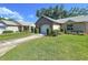 Beautifully landscaped home with lush green grass and trimmed bushes leading to the attached one car garage at 4836 Alamo Ct, New Port Richey, FL 34655