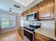 Kitchen with stainless steel appliances, granite counters, wood cabinets, and natural light at 4836 Alamo Ct, New Port Richey, FL 34655