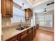Bright kitchen featuring wood cabinets, granite counters, and natural lighting from a window with shutters at 4836 Alamo Ct, New Port Richey, FL 34655