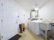 Functional laundry room with white washer, dryer, and utility sink, plus a door to the outside at 4836 Alamo Ct, New Port Richey, FL 34655