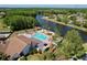 A relaxing community pool overlooking a beautiful lake, surrounded by lush landscaping and palm trees at 4836 Alamo Ct, New Port Richey, FL 34655