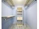 Spacious walk-in closet featuring shelving and light-blue painted walls at 4836 Alamo Ct, New Port Richey, FL 34655