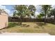 The backyard features a wooden fence for privacy, a few scattered trees, and a storage shed at 5092 Roble Ave, Spring Hill, FL 34608