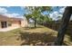 Spacious fenced backyard with mature tree shading the lawn area at 5092 Roble Ave, Spring Hill, FL 34608