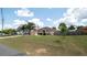 A charming single-story home with lush front lawn, palm trees, and an American flag at 5092 Roble Ave, Spring Hill, FL 34608