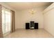 Empty living room with tiled floors, vaulted ceiling, large window, and chandelier lighting at 5092 Roble Ave, Spring Hill, FL 34608