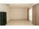 Open room with tiled floors, large window with curtains, and a dark green gun safe at 5092 Roble Ave, Spring Hill, FL 34608