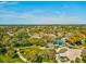 An aerial view showcasing a park with walking paths and a playground amidst lush trees and greenery at 6329 Alaska Ave, New Port Richey, FL 34653