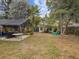 Lush backyard features mature trees, a patio with furniture, and well-manicured landscaping at 6329 Alaska Ave, New Port Richey, FL 34653
