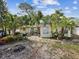 Spacious backyard with mature trees, landscaping, and a stone patio at 6329 Alaska Ave, New Port Richey, FL 34653