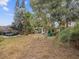 Spacious backyard features mature trees, a covered patio, and lush landscaping at 6329 Alaska Ave, New Port Richey, FL 34653