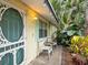 Charming front porch with seating area and tropical landscaping at 6329 Alaska Ave, New Port Richey, FL 34653