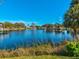 Scenic lake view with a fountain, bridge, and lush greenery under a clear blue sky, perfect for relaxation at 6329 Alaska Ave, New Port Richey, FL 34653