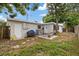 Backyard featuring a grill, hammock, and lush green lawn on a sunny day at 6335 Kings Ct, New Port Richey, FL 34653