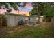 Backyard featuring a grill, hammock, and lush green lawn at sunset at 6335 Kings Ct, New Port Richey, FL 34653