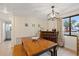 Bright dining area with modern lighting, bar, table and bench, large windows, and light tile floors creating comfortable space at 6335 Kings Ct, New Port Richey, FL 34653