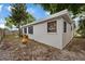 View of home exterior with a neutral paint and green plants and trees at 6335 Kings Ct, New Port Richey, FL 34653