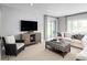 Comfortable living room with neutral-colored furnishings, a large TV, and sliding glass doors at 6770 Pebblebrooke Way, Zephyrhills, FL 33541