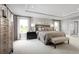 Spacious main bedroom with a tray ceiling, seating, and serene view at 6770 Pebblebrooke Way, Zephyrhills, FL 33541