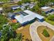 Aerial view of the home featuring a pool enclosure, well-manicured lawn, and long circular driveway at 7230 17Th N Ln, St Petersburg, FL 33702